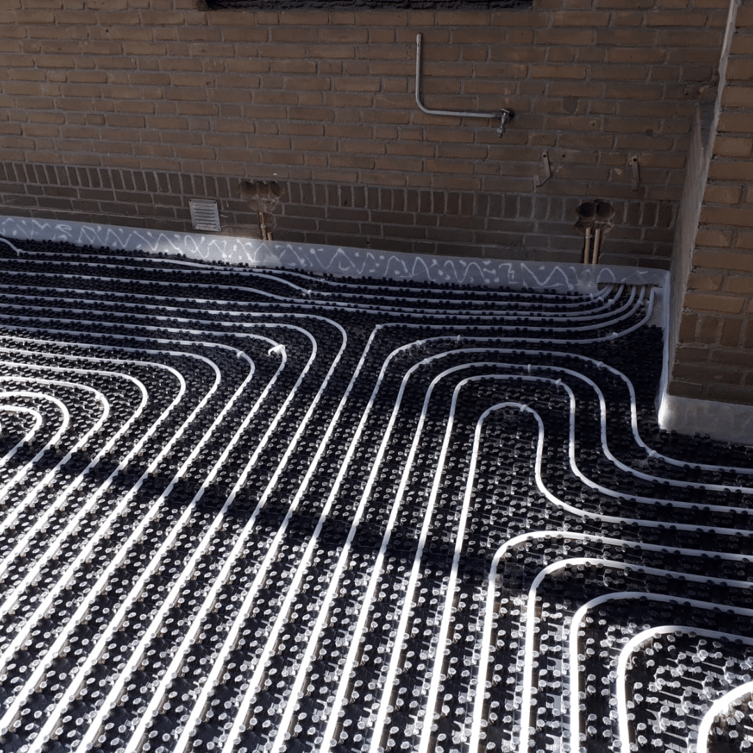 "Wavin vloerverwarmingsbuis gemonteerd op een noppenplaat, uitgevoerd door Esveld Installatie."