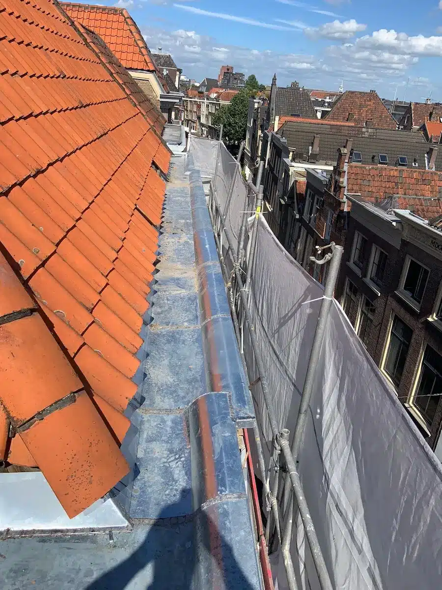 Nieuwe zinken dakgoot plaatsen en vakkundig vervangen langs een schuin pannendak door een zink specialist.