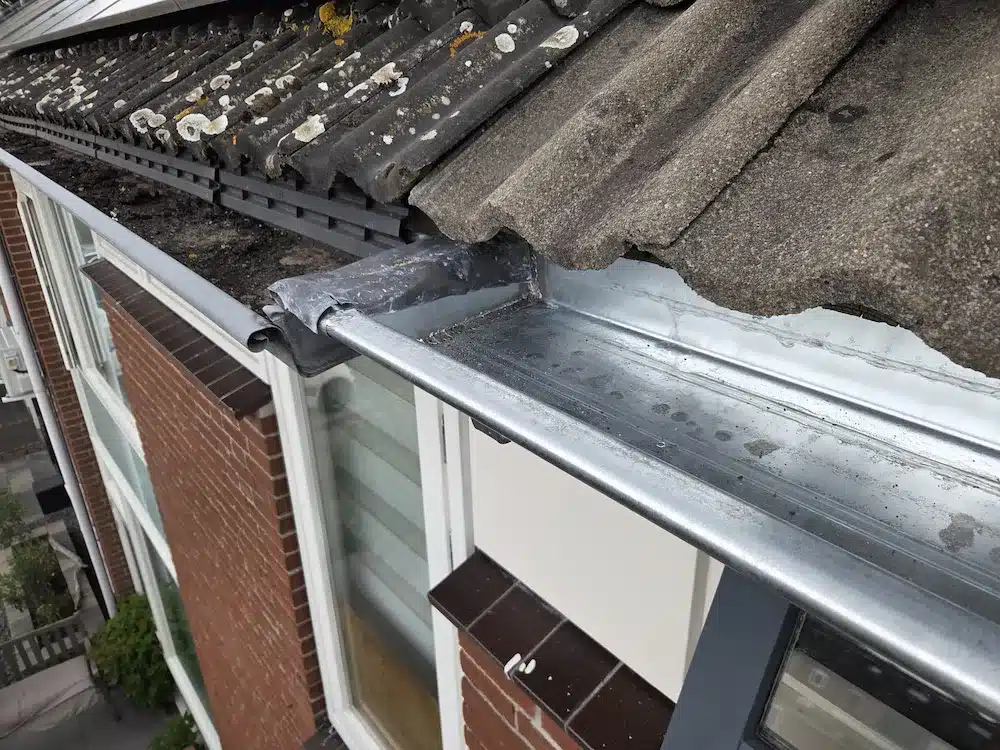 Waterdichte aansluiting tussen de nieuwe dakgoot van het hoofddak en de goot boven de aanbouw