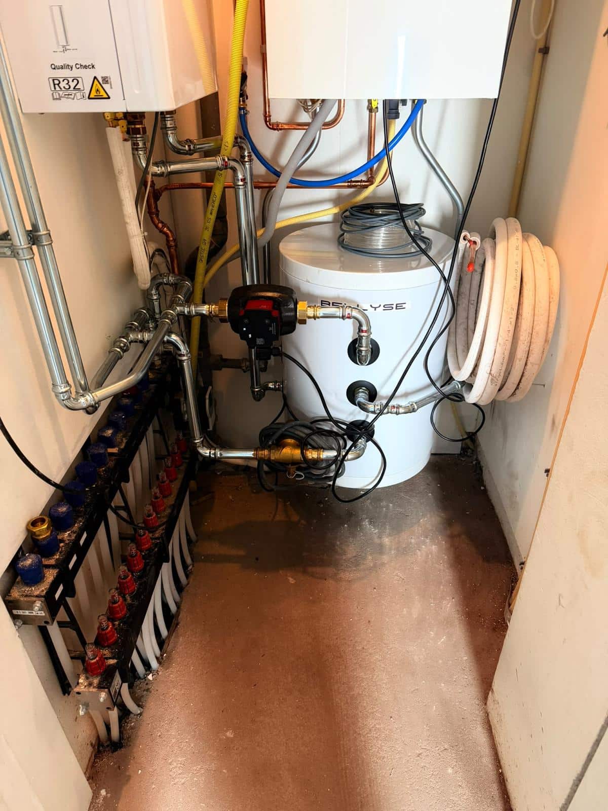 Verdeler voor vloerverwarming met circulatiepomp en rvs perskoppelingen bij het buffervat