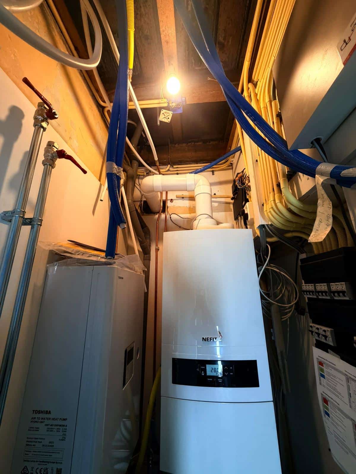 Toshiba hydromodule naast een Nefit cv-ketel met rookgasafvoer in de installatieruimte